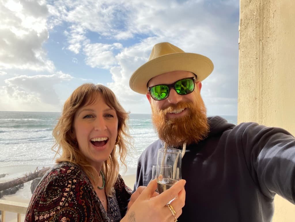 Garrett and Lindsay with champagne by the ocean
